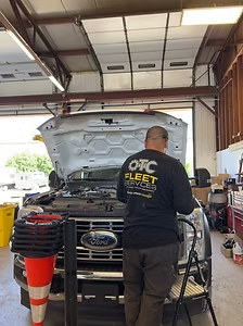 OTC technician servicing a Ford fleet vehicle in the shop