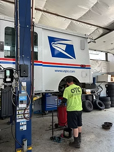 OTC technician working on a USPS mail truck on the lift